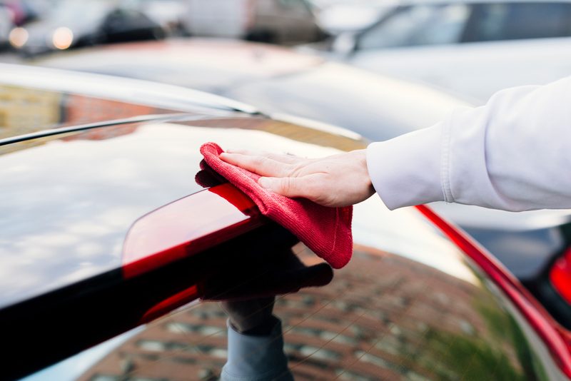 Essuyage d’une carrosserie rouge avec une microfibre